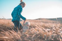 Woman walking child through field